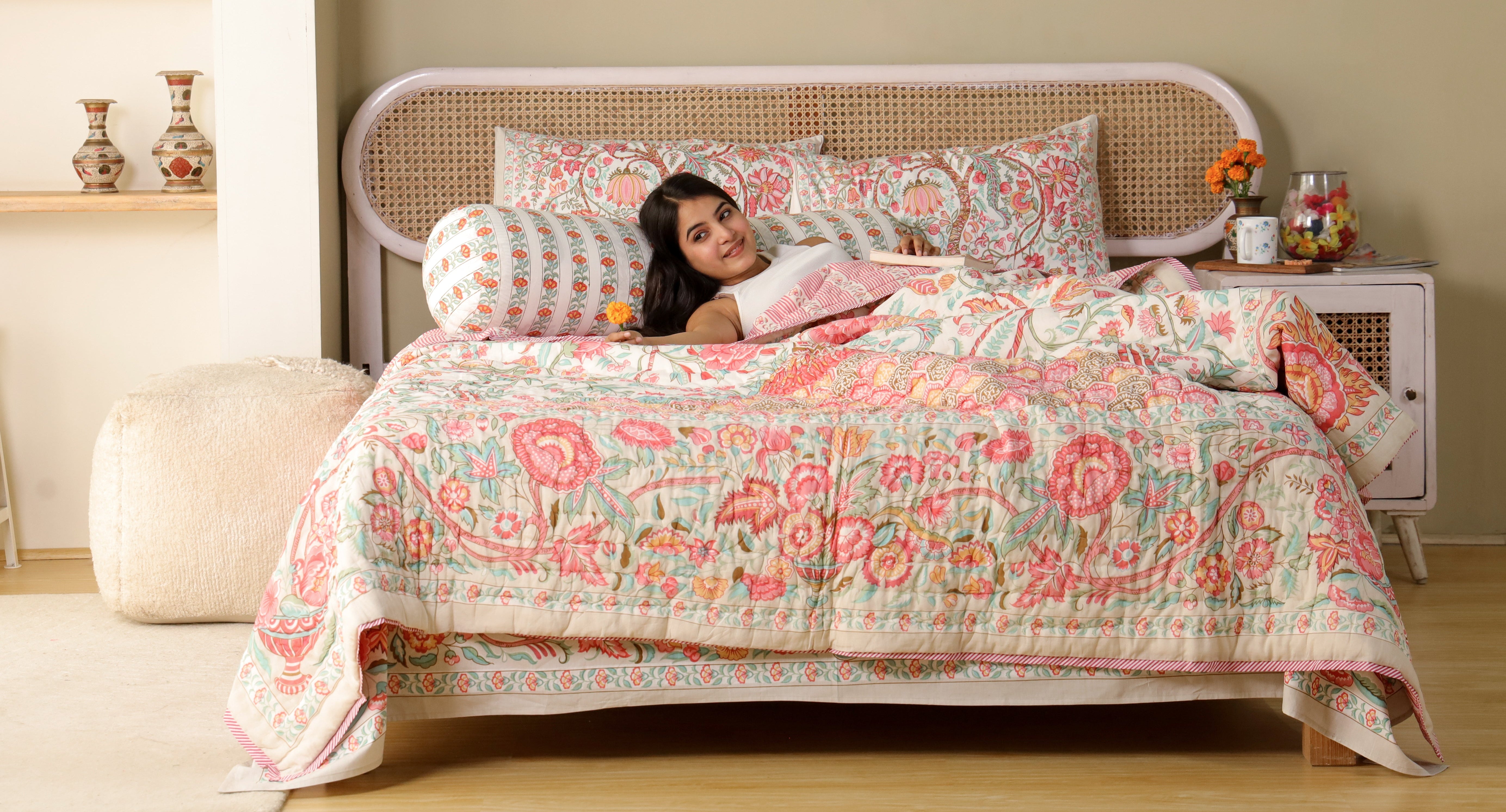 Woman lying on a bed with floral bedding in a bedroom setting
